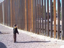Boy Playing Catch Through Current Barred Wall